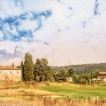 agriturismo-toscana-pisa (2) Un campo da golf con una casa sullo sfondo.